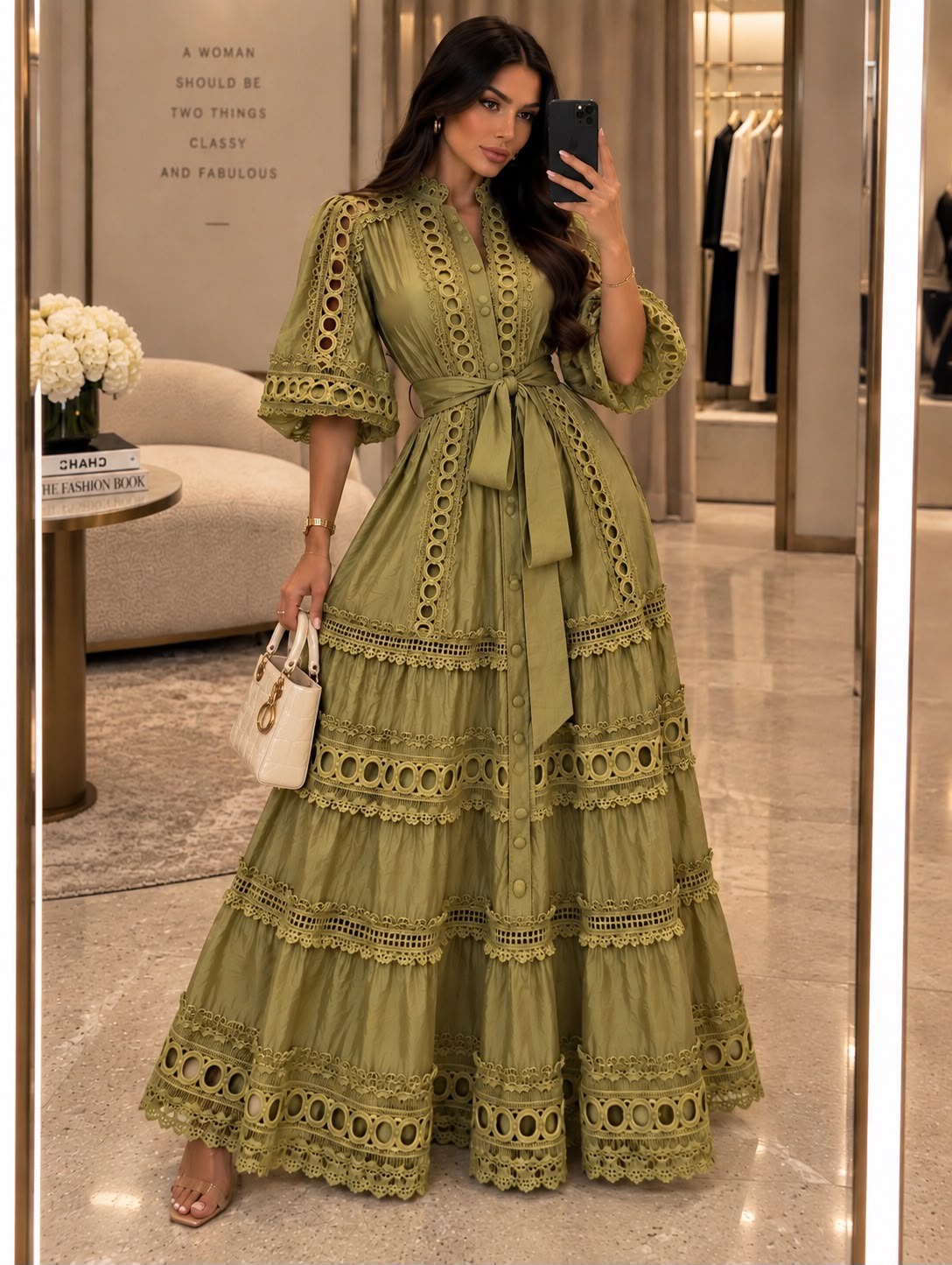 Woman wearing an olive green tiered maxi shirt dress with ornate cutout lace trim and a tie waist